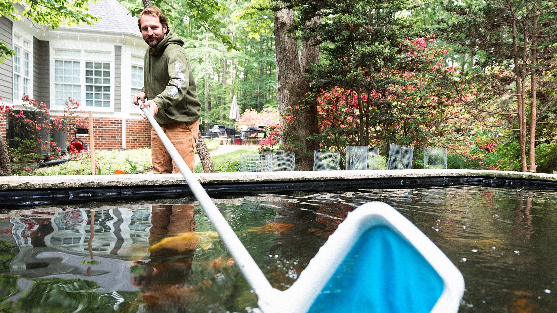 Cooper cleaning a pond with a net.